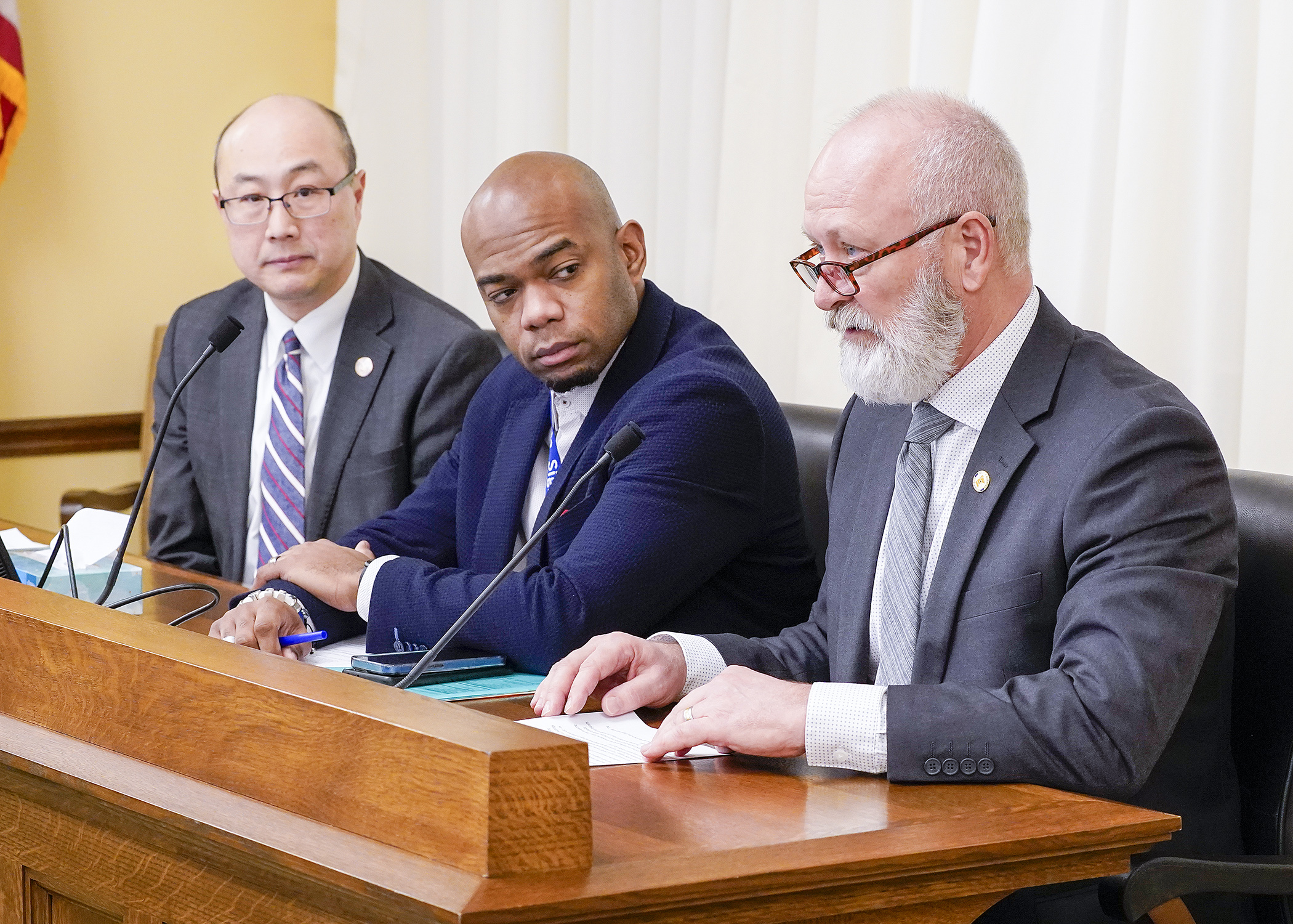 Ramsey County Attorney John Choi, left, and Public Safety Commissioner Bob Jacobson, right, were among testifiers before the House's public safety committee Feb. 3 in support of HF15. Rep. Cedrick Frazier, center, is the sponsor. (Photo by Andrew VonBank)